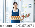 A middle-aged woman selling bread at a cafe. Photo courtesy of Denpa Gakuen Educational Foundation, Tokyo Electronics College. 141671071