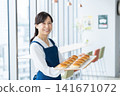 A middle-aged woman selling bread at a cafe. Photo courtesy of Denpa Gakuen Educational Foundation, Tokyo Electronics College. 141671072