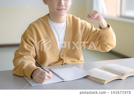 一個男人正在快樂地在筆記本上寫字,象徵目標的實現和學習。 一個男人正在快樂地在筆記本上寫字,象徵目標的實現和學習。 141671978