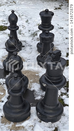 Large outdoor chess pieces on the snow in a park Large outdoor chess pieces on the snow in a park 141672879