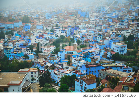 Overhead view of blue-painted houses in Chefchaouen medina on a misty hillside Overhead view of blue-painted houses in Chefchaouen medina on a misty hillside 141673160