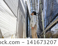 Site supervisor checks the joint between the new exterior wall and window frame. 141673207