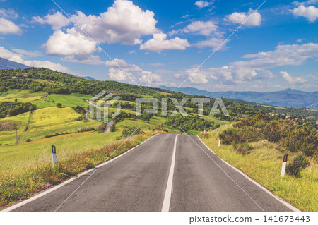 Beautiful landscape, spring nature. Winding provincial road among sunny fields in Tuscany, Italy Beautiful landscape, spring nature. Winding provincial road among sunny fields in Tuscany, Italy 141673443