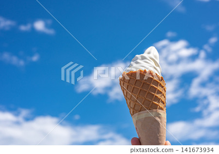 有人在藍天下舉著冰淇淋甜筒──這是典型的夏日景象。 有人在藍天下舉著冰淇淋甜筒──這是典型的夏日景象。 141673934