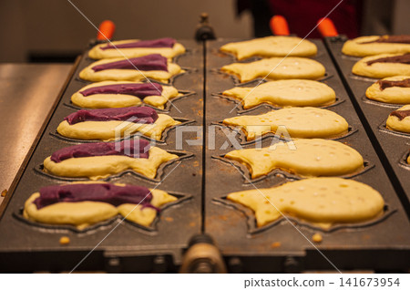 The process of baking the purple sweet potato filling for Momiji Manju, an image of Japanese confectionery making. 141673954