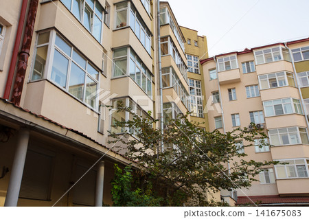 Modern architecture in urban courtyard with greenery during late afternoon Modern architecture in urban courtyard with greenery during late afternoon 141675083