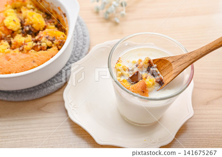 Scoop cookies to eat by dipping them in milk. Scoop cookies to eat by dipping them in milk. 141675267