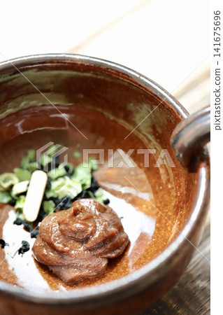 Mix the dried ingredients of instant miso soup before adding hot water with the miso paste. Mix the dried ingredients of instant miso soup before adding hot water with the miso paste. 141675696