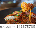一個人用叉子叉起一份番茄醬蟹肉意麵。 141675735