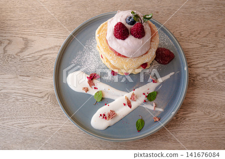 Pancakes adorned with berries, reminiscent of cafe sweets. Pancakes adorned with berries, reminiscent of cafe sweets. 141676084