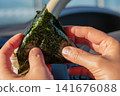 一個人雙手捧著自製飯糰的畫面，讓人聯想到日本料理。 141676088
