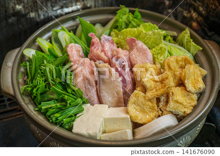 A clay pot filled with duck meat and vegetables, reminiscent of a winter hot pot dish. A clay pot filled with duck meat and vegetables, reminiscent of a winter hot pot dish. 141676090