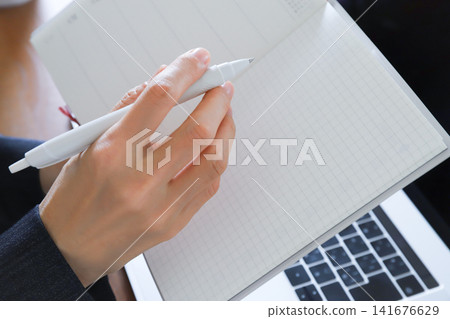 A woman's hands holding a notebook and pen - Business A woman's hands holding a notebook and pen - Business 141676629