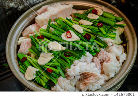 用砂鍋烹調的菜餚，包含韭菜和蒜等食材，用來製作韭菜火鍋。 141676801