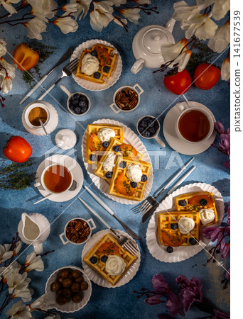 Waffles with persimmon blueberries and whipped cream elegant tea party Waffles with persimmon blueberries and whipped cream elegant tea party 141677539