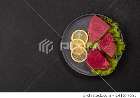 Raw tuna steaks with lemon and lettuce Raw tuna steaks with lemon and lettuce 141677553