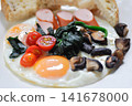 fried egg or sunny side up egg with vegetable topping and bread or breakfast 141678000