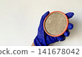 Dirty Round Air Filter Held in Gloved Hand for Maintenance and Replacement 141678042