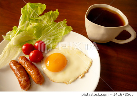 Breakfast plate with fried eggs, sausage and coffee. 141678563