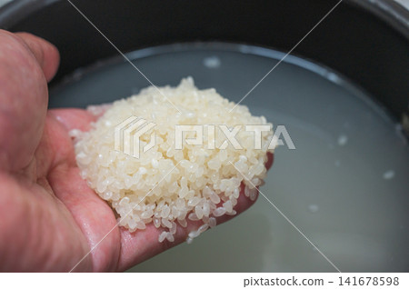 手中洗淨的米,煮熟前的特寫。 手中洗淨的米,煮熟前的特寫。 141678598