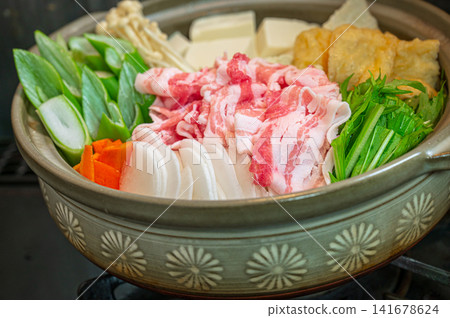 準備色彩繽紛的蔬菜豬肉火鍋食材,並將它們放在陶鍋中。 準備色彩繽紛的蔬菜豬肉火鍋食材,並將它們放在陶鍋中。 141678624
