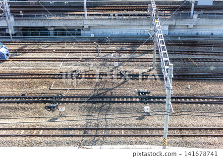 A bird's-eye view of railway tracks and overhead line poles in the morning light: a landscape of railway and transportation infrastructure. A bird's-eye view of railway tracks and overhead line poles in the morning light: a landscape of railway and transportation infrastructure. 141678741