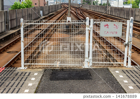 The no-entry fence at the end of the station platform and the tracks, at eye level. The no-entry fence at the end of the station platform and the tracks, at eye level. 141678889