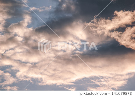 Dramatic dark storm clouds catching golden warm sunlight during sunset Dramatic dark storm clouds catching golden warm sunlight during sunset 141679878
