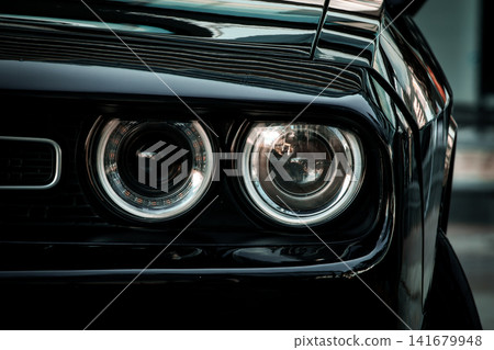 Black Muscle Car Front End Close Up with Dual Headlights and Aggressive Grille Black Muscle Car Front End Close Up with Dual Headlights and Aggressive Grille 141679948