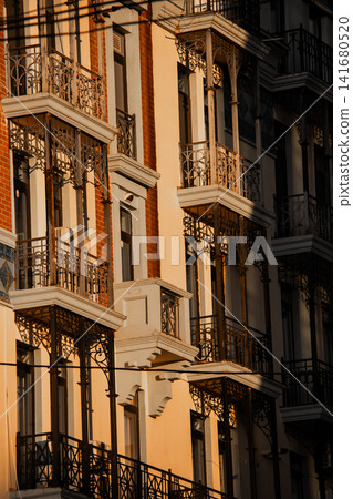 Elegant Residential Building Facade with Ornate Iron Balconies in Golden Hour Light, Architectural Elegant Residential Building Facade with Ornate Iron Balconies in Golden Hour Light, Architectural 141680520