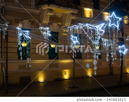 Lights on the street at night. City square on New Year's Day. Garlands for decoration. Holiday symbols. Networking garlands Lights on the street at night. City square on New Year's Day. Garlands for decoration. Holiday symbols. Networking garlands 141681621