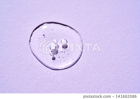 Cosmetics serum drop on purple background texture Cosmetics serum drop on purple background texture 141682086