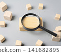 A background image of wooden blocks used for investigation and analysis with a magnifying glass. 141682895
