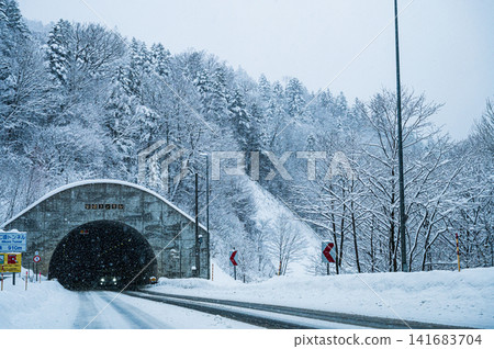 穿過雪山的隧道,冬日雪景,大雪紛飛。 穿過雪山的隧道,冬日雪景,大雪紛飛。 141683704