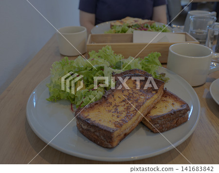 清晨在咖啡館享用一份香噴噴的法式吐司,是多麼令人愉悅。 清晨在咖啡館享用一份香噴噴的法式吐司,是多麼令人愉悅。 141683842