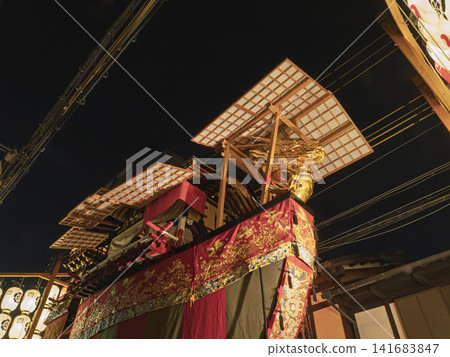 禦船馱花車的金色龍頭在夜空中閃耀,是祗園祭宵山(晚祭)的壯觀景象。 禦船馱花車的金色龍頭在夜空中閃耀,是祗園祭宵山(晚祭)的壯觀景象。 141683847