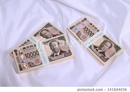 A stack of 10,000 yen bills placed on a cloth. A stack of 10,000 yen bills placed on a cloth. 141684036