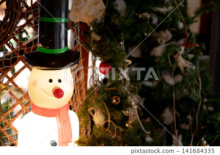 A snowman in a top hat and a Christmas tree A snowman in a top hat and a Christmas tree 141684335