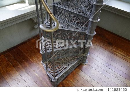 Ornate Cast Iron Spiral Staircase on Wood Floor Ornate Cast Iron Spiral Staircase on Wood Floor 141685460