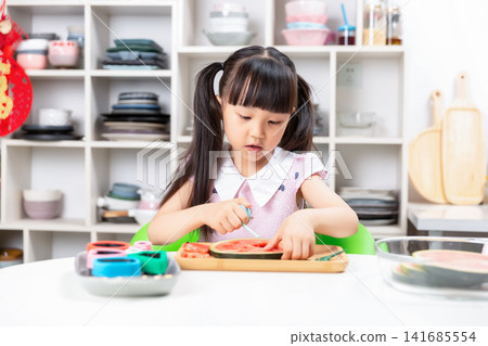 Cute Asian girl making fun shapes with watermelon in kitchen, happy emotion, healthy eating and childhood creativity concept Cute Asian girl making fun shapes with watermelon in kitchen, happy emotion, healthy eating and childhood creativity concept 141685554