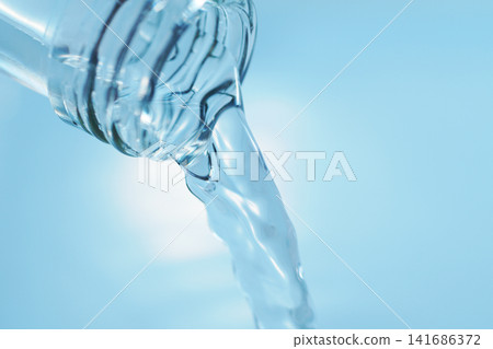 用玻璃瓶倒入礦泉水。 用玻璃瓶倒入礦泉水。 141686372