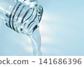 Pour in mineral water from a glass bottle. 141686396