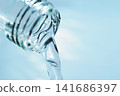 Pour in mineral water from a glass bottle. 141686397