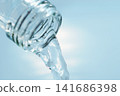 Pour in mineral water from a glass bottle. 141686398