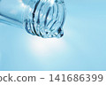 Pour in mineral water from a glass bottle. 141686399