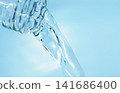Pour in mineral water from a glass bottle. 141686400