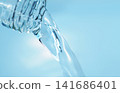 Pour in mineral water from a glass bottle. 141686401