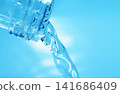 Pour in mineral water from a glass bottle. 141686409