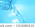 Pour in mineral water from a glass bottle. 141686410