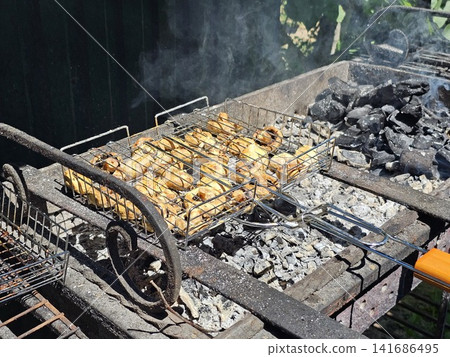 Marinated button mushrooms roasting on barbecue grill with smoky flavor and crispy caramelized surface Marinated button mushrooms roasting on barbecue grill with smoky flavor and crispy caramelized surface 141686495